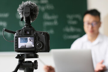 Wall Mural - Asian teacher conducting English lesson online