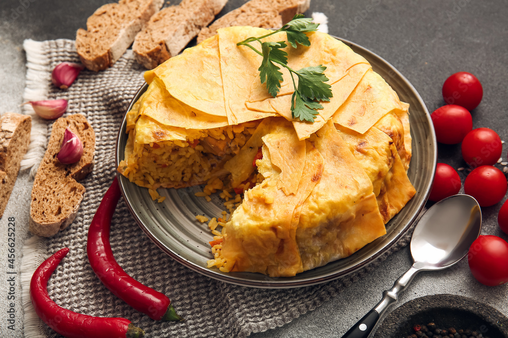 Plate with tasty Shah Pilaf and vegetables on grunge background