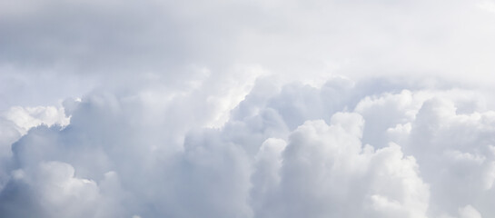 Cloudy sky background with sunlight shining through the white clouds.