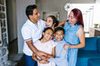 © Marcos - Portrait of happy hispanic family and teenage daughter with cerebral palsy at home in Latin America in disability concept