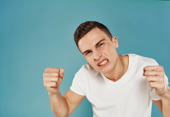 Wall Mural - man in a white t-shirt gesturing with his hands emotions close-up