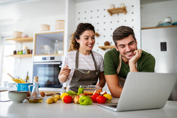 Wall Mural - Happy young couple have fun in kitchen while preparing healthy organic food