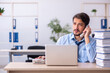 © Elnur - Young male employee and too much work in the office
