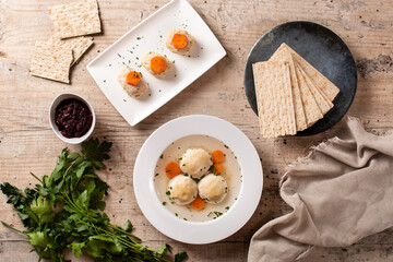 Canvas Print - Traditional Jewish matzah ball soup, gefilte fish and matzah bread on wooden table	