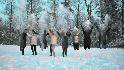 Wall Mural - Cheerful girls throw snow on the background of a snow-covered forest.