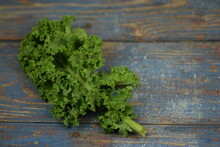 Kale Single Leaf On Blue Vintage Wooden Background, Green Curly Leaf Of Kale.