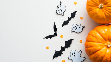 Happy Halloween holiday flat lay composition with cute decorations. Top view pumpkins, ghosts, bats on white background.