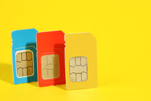 Different SIM Cards On Yellow Background. Space For Text
