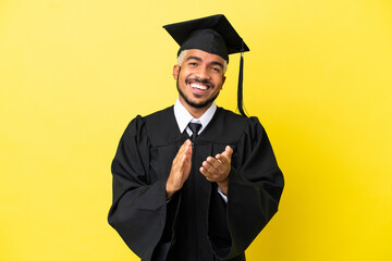 Poster - Young university graduate Colombian man isolated on yellow background applauding after presentation in a conference