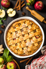 Wall Mural - Apple pie with ginger and cinnamon at dark wooden table. Traditional autumn baking. Top view image with copy space.