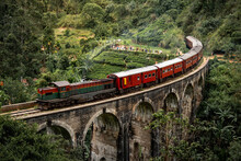 Red Classic Train On Nine Arches Bridge, Running Over Ceylon Tea Plantation In Ella. Famous Tourist Attraction Of Sri Lanka.