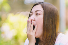 Thai Woman Covering Her Mouth While Yawning.
