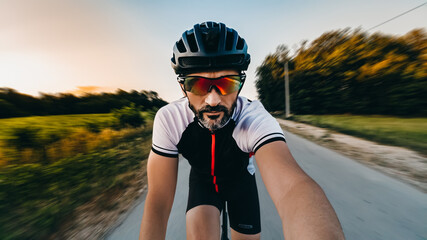 Poster - Closeup shot of a bicycle rider on the road making a selfie during the riding