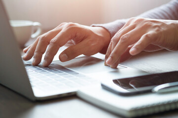 Close-up of man hand using and typing keyboard of laptop computer on office desk. Workspace, businessman working project creative idea for job online network. Business finance and technology concept.