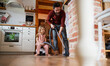 Father with small daughter hoovering indoors at home, daily chores concept.