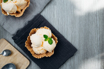 Wall Mural - homemade Ice cream scoops with vanilla ice cream in a bowl with mint. Top view