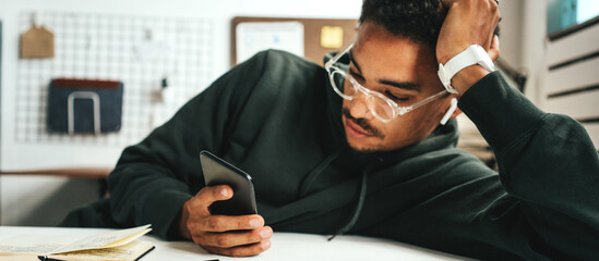 Investing in stock exchange market. Black casual man working using mobile phone app, wide screen