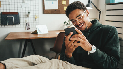Investing in stock exchange market. Happy smiling black casual man working using mobile phone app