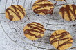 Banana coconut cookies drizzled with melted chocolate on cooling rack