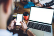 © BullRun - Unrecognizable man using smartphone and laptop at table with colleagues