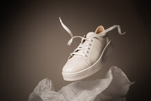 Fashion - White Leather Unisex Sneakers Shoe Levitating On The Gray Background