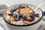 Fototapeta Mapy - Tasty oatmeal porridge with toppings served on table, closeup