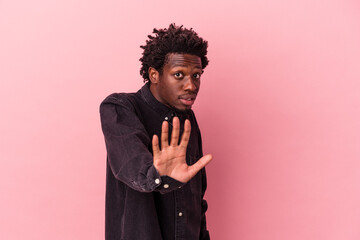 Wall Mural - Young african american man isolated on pink background being shocked due to an imminent danger