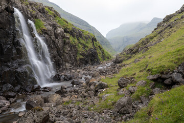 Wall Mural - The top of the mountain of Faroe islands. A view of high peaks of mountains on a sunny day. Ocean view. 
Beautiful panoramic view. Northern Europe. Travel concept