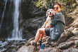 © Soloviova Liudmyla - Smiling Female dog owner hugging his friend beagle dog resting near the mountain river waterfall during their together walking in autumn season time. Human and pets or walking in nature concept image.