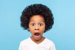 © khosrork - Wow, unbelievable! Portrait of funny caricature amazed little curly boy looking at camera with shocked big eyes, emotionally reacting to surprising news. indoor studio shot isolated on blue background
