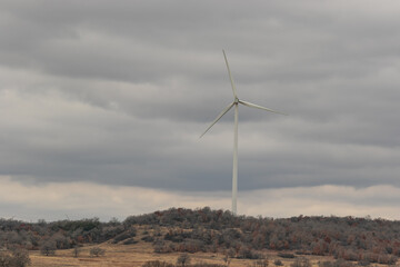  One wind turbine in a field with storm clouds 