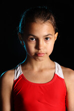 Close-up Portrait Of A Bright Beautiful Girl Swimmer 12 Years Old On A Black Background. She Has Slicked Hair And Looks Eye To Eye.