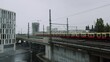 Red train is passing through bridge on rainy day in Berlin, Germany