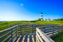 A Turn Of The Boardwalk At The Bodie Island Lighthouse In The Outer Banks In North Carolina Under A Blue Sky.