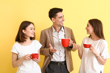 Wall Mural - Business colleagues drinking coffee on color background