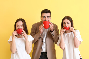 Wall Mural - Business colleagues drinking coffee on color background