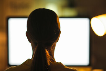 Young woman working on computer in evening