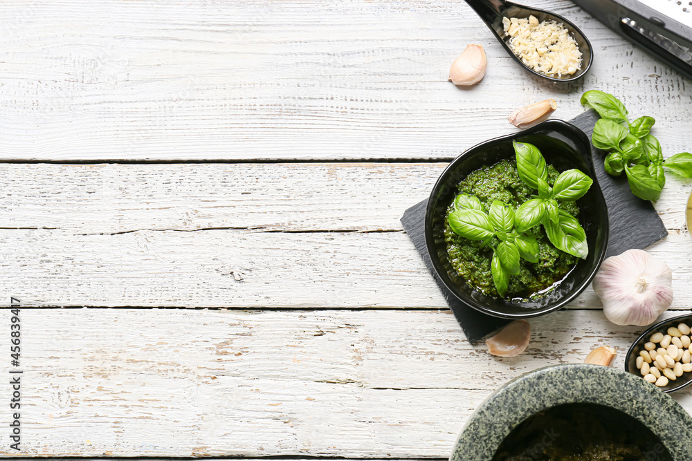Composition with tasty pesto sauce on white wooden background