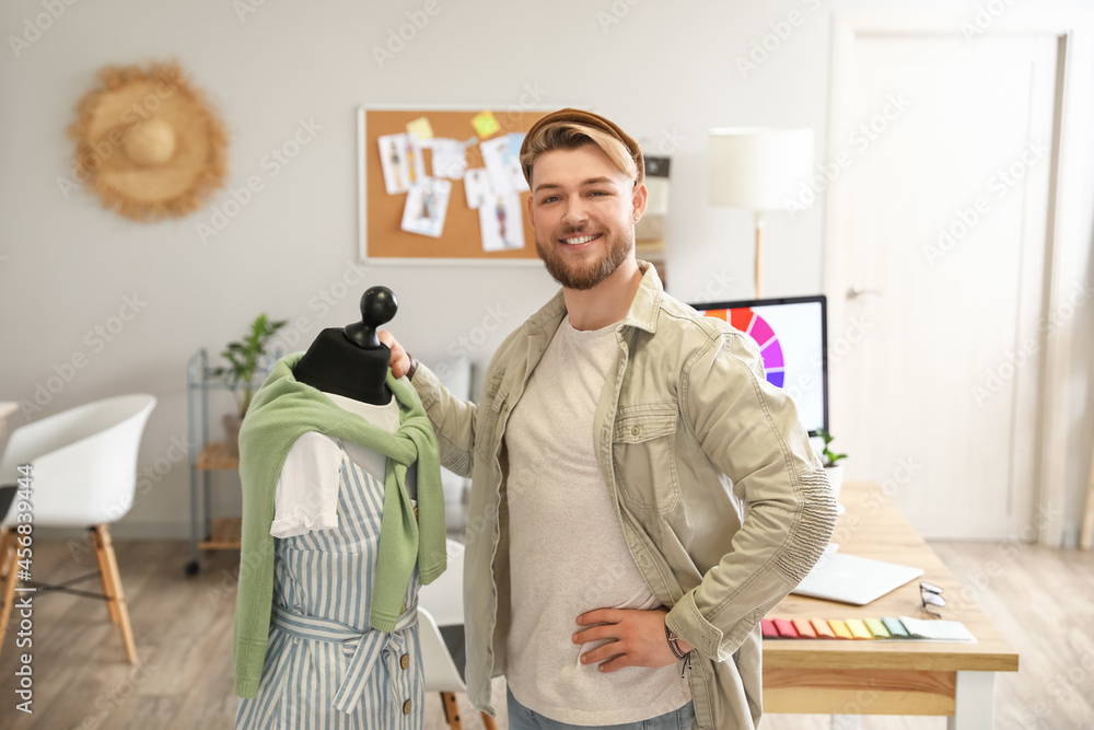 Male stylist with mannequin in studio