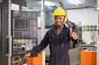 © Akarawut - Portrait of African American mechanic engineer worker wearing safety equipment showing thumbs up beside the automatic lathe machine in the manufacturing factory