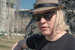 Close-up of a young albino man wearing a hat and dark glasses to protect himself from the sun.