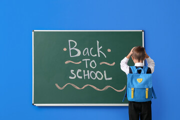 Sticker - Stressed schoolboy near blackboard on color background