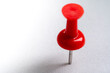canvas print picture - red push pin stuck in white floor. Macro thumbtack top view. white background and copy space