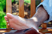 Man Relaxing His Sore Feet Outdoors.