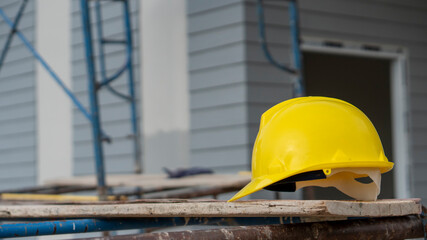 Wall Mural - Safety helmet (hard hat) for engineer, safety officer, or architect, place on cement floor. Yellow safety hat (helmet) in construction site.