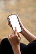 © amnaj - Close-up of a businesswoman hand holding a smartphone with a blank white screen work at the office. Mock up.