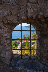 Wall Mural - View of the city of Herceg Novi, blue sea and buildings through the hole in the stone wall of the fortress, Montenegro