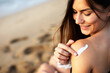 © Jelena - Woman using sunscreen cream. Beautiful girl with sun protection cream.