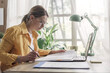 © StockPhotoPro - Young businesswoman sitting at desk and working from home