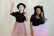 Two cute girls with halloween makeup performing pantomime in front of camera